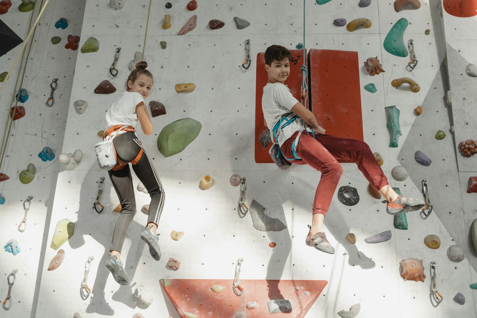 Two children on an indoor climbing wall during a club session
