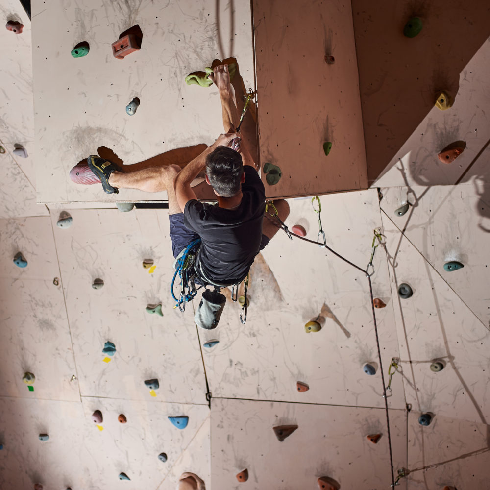 Climber on an indoor wall, viewed from behind